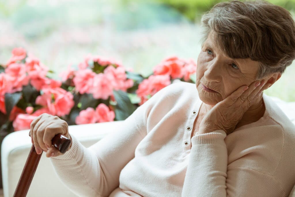 old lady sitting out with a sad face