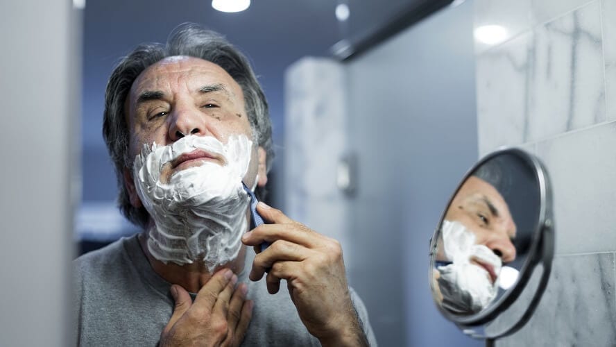 man shaving his beard