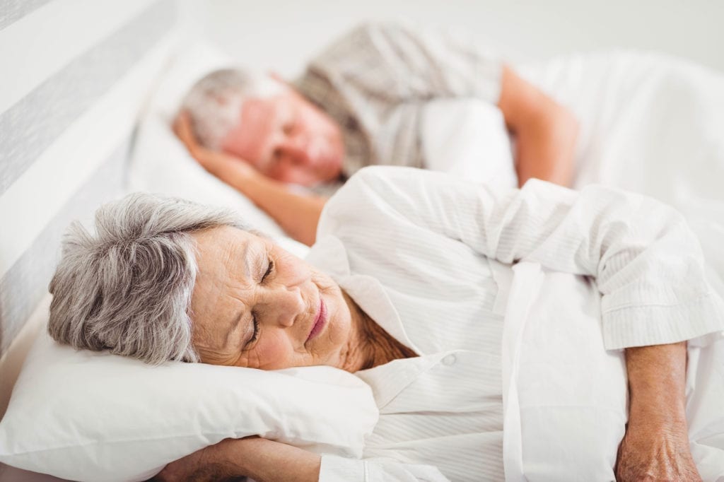 Senior couple sleeping on bed