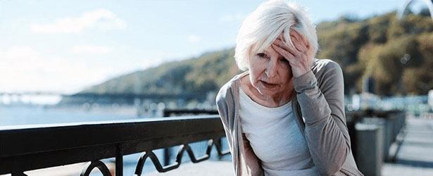 old women touching her head because of pain